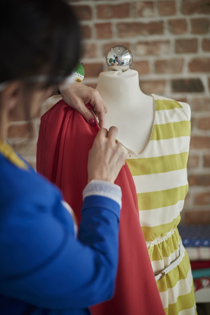 Rear view of woman in design studio draping fabric onto mannequin