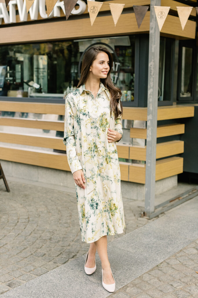 Street fashion photoshoot. Portrait of young beautiful woman walking in the city. Model looking aside. Wearing casual outfit